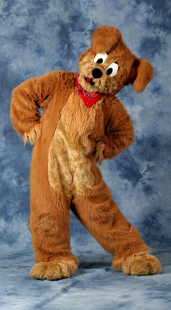 A photo of JD Puppy, a brown floppy eared puppy dog wearing a red bandana, from the Dragonscales Studio setup.